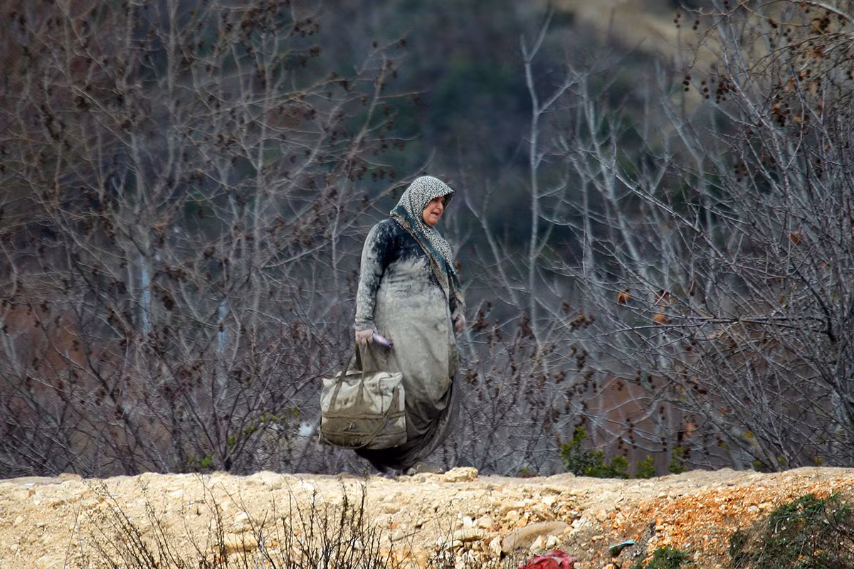 Một người tị nạn Syria mang theo hành lý đi bộ ở thị trấn Khirbet Al-Joz, Latakia ngày 7/2/2016.