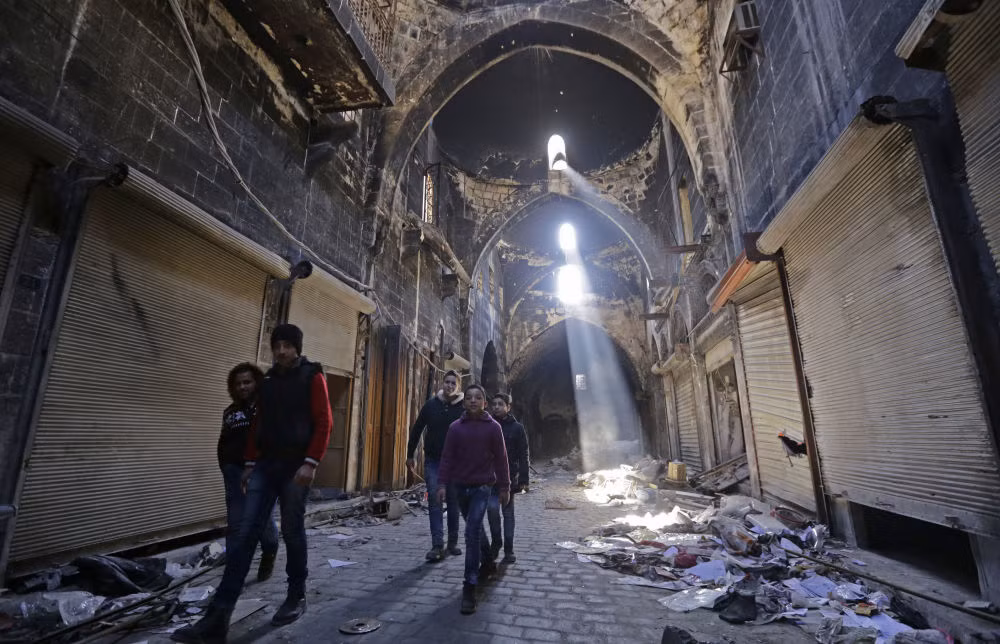 Các em nhỏ Syria đi bộ qua một con phố ngổn ngang ở Aleppo.