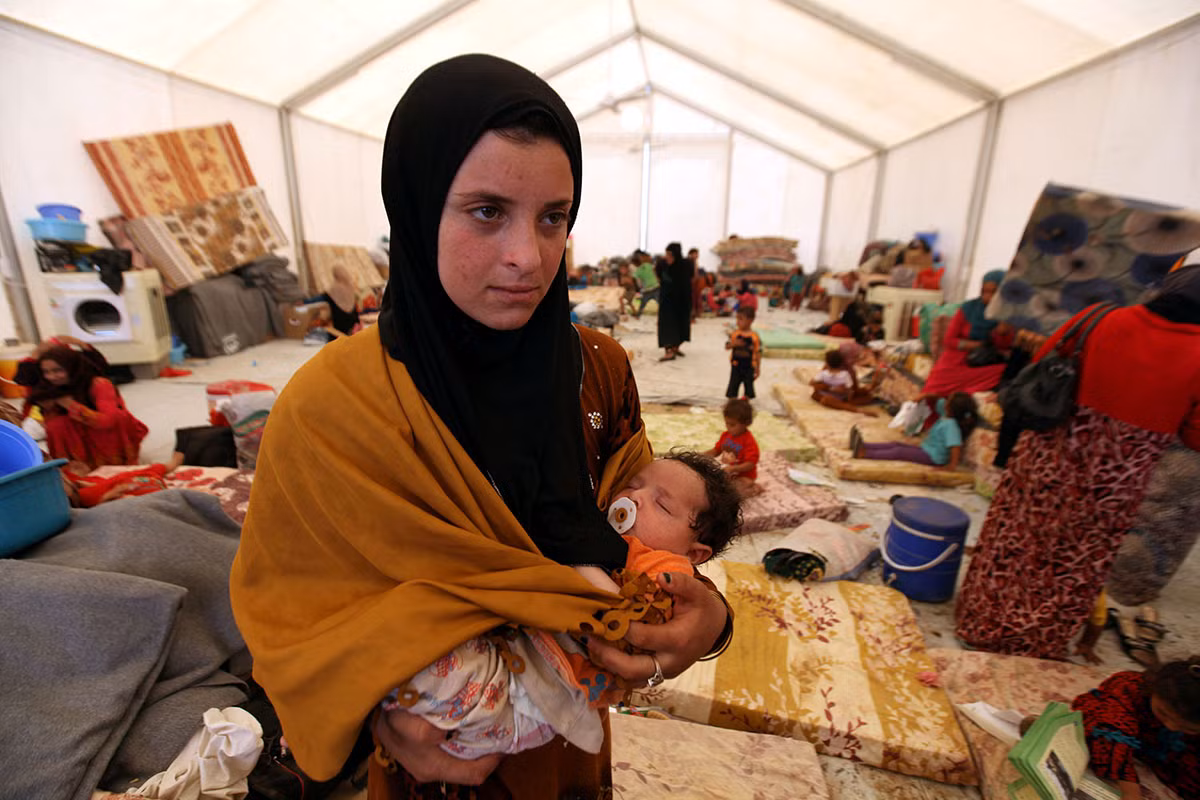 Người phụ nữ bế con trong khu trại tị nạn ở khu Makhmour, gần thành phố Mosul, Iraq, ngày 15/6/2016.