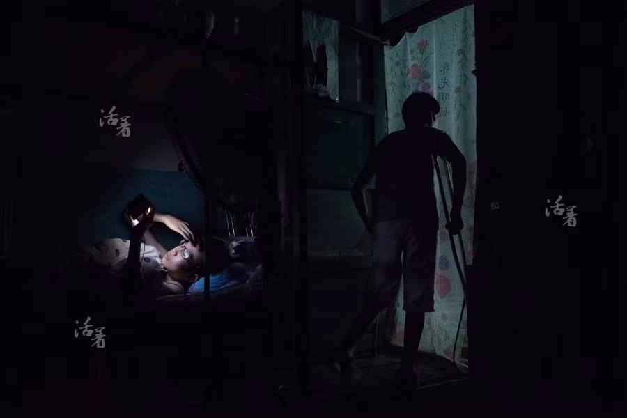 Một sinh viên xem điện thoại di động trong ký túc xá của trường sau khi đèn điện bị tắt vào lúc 11 giờ tối. Theo quy định, sinh viên ở đây sẽ bị cấm uống rượu, hút thuốc, đánh nhau và hẹn hò trong trường.