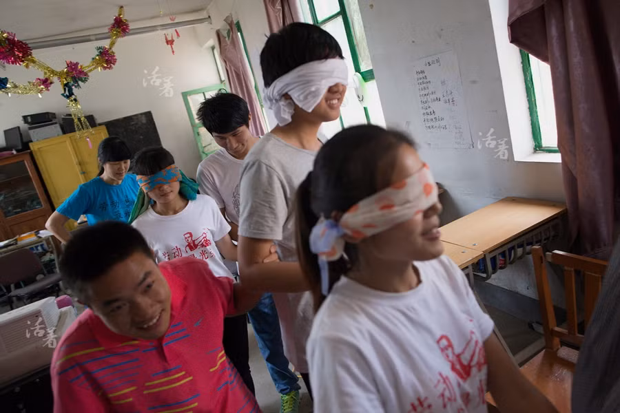 Một số lao động nhập cư đang chơi trò chơi có tên “Trust” trong trường học ngày 10/7/2015.