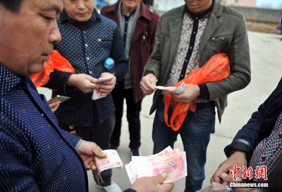 Chủ doanh nghiệp phát tiền cho các nông dân.