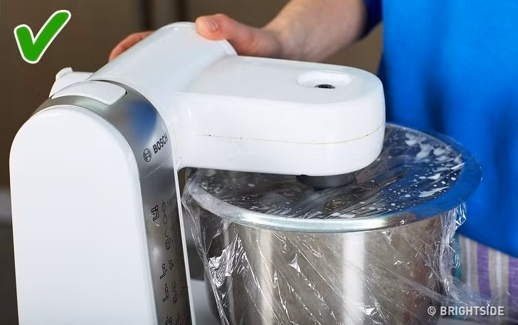 Để tránh trộn thức ăn bắn tung tóe ra bếp, bạn có thể bọc miệng bát thực phẩm bằng màng bọc.