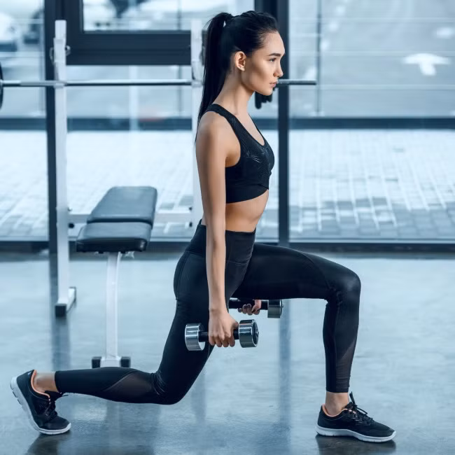 Nhảy với tạ ở 2 tay là một bài tập giúp bắp chân thon gọn hiệu quả vô cùng. Giữ tạ ở hai bên tay với một chân bước lên phía trước mặt khác, đầu gối vuông góc. Nhảy lên và thay đổi chân.