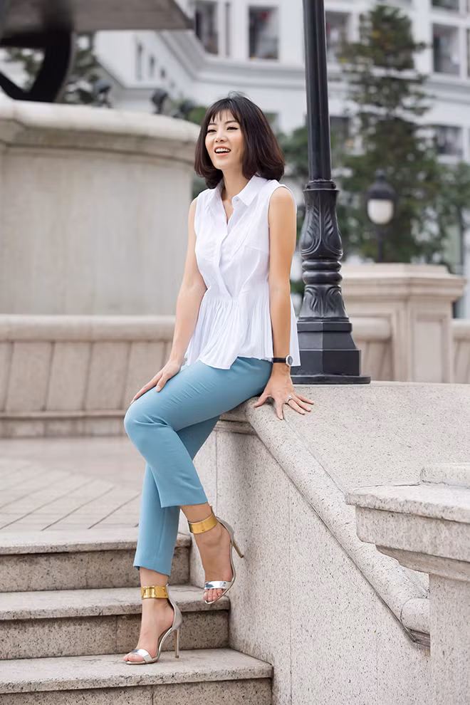 Set đồ áo sơ mi trắng cách điệu với quần xanh của cô cũng thích hợp cho các nàng công sở.