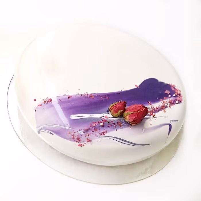 Bánh có bề ngoài như chiếc gương, được tô điểm với các đường vân nhiều màu sắc.