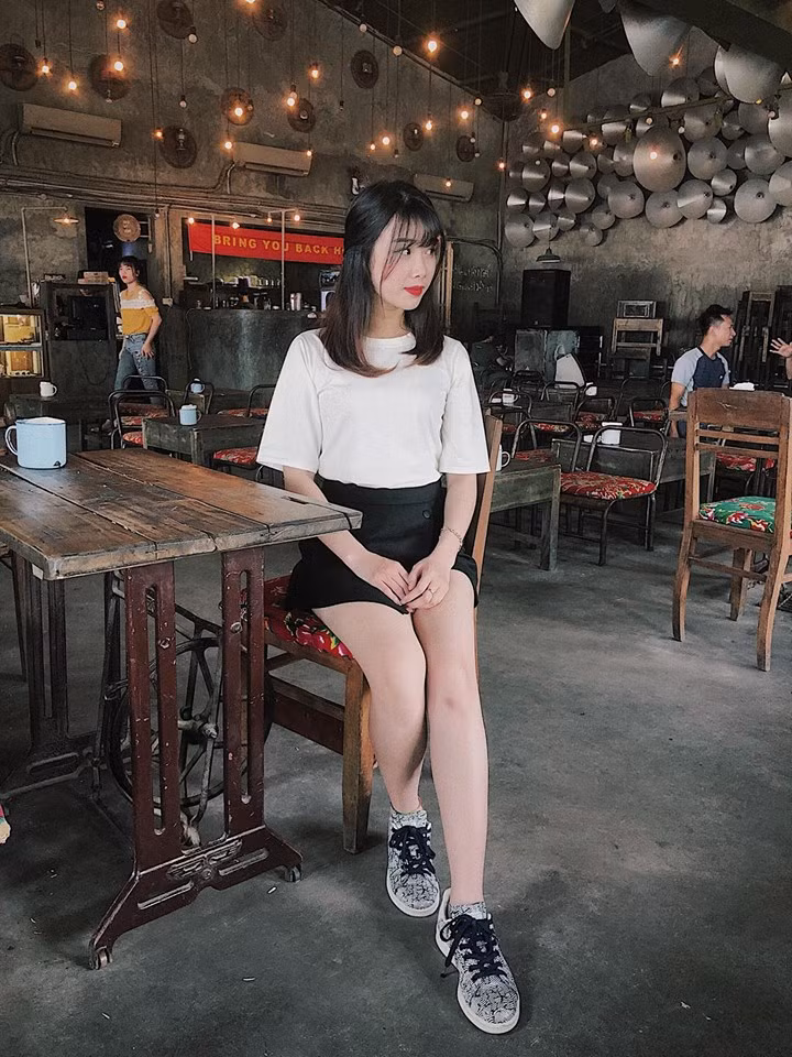 Áo phông trắng và váy đen mix với giày thể thao giúp cô nàng trông vừa cá tính vừa dễ thương.