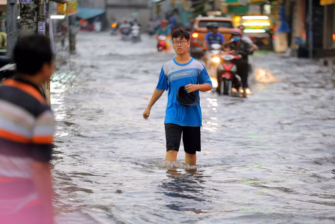 Nước ngập lênh láng khiến nhiều xe cộ chết máy, người dân lội bì bõm, vất vả về nhà.