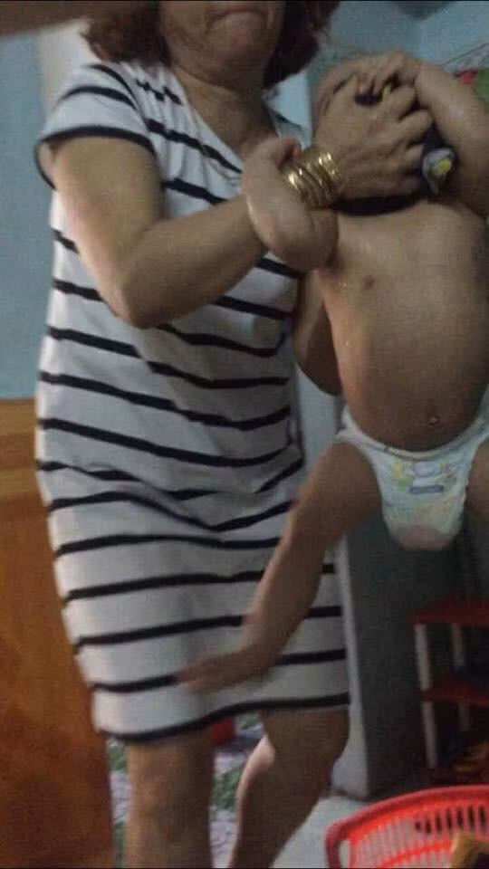 Hình ảnh em bé giãy giụa vì bị bảo mẫu bịt mặt khiến nhiều người phẫn nộ - Ảnh: Facebook.