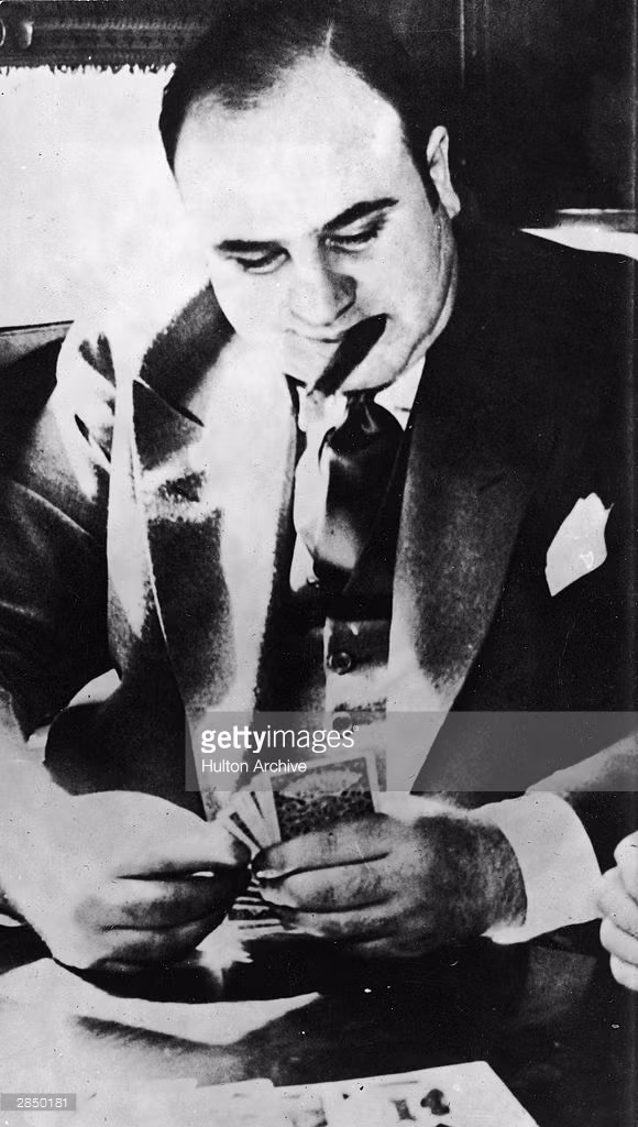 Al Capone chơi bài trong khoang xe lửa trong quá trình vận chuyển đến nhà tù để chịu hình phạt cho tội trốn thuế, tháng 10/1931. Ảnh: Getty.