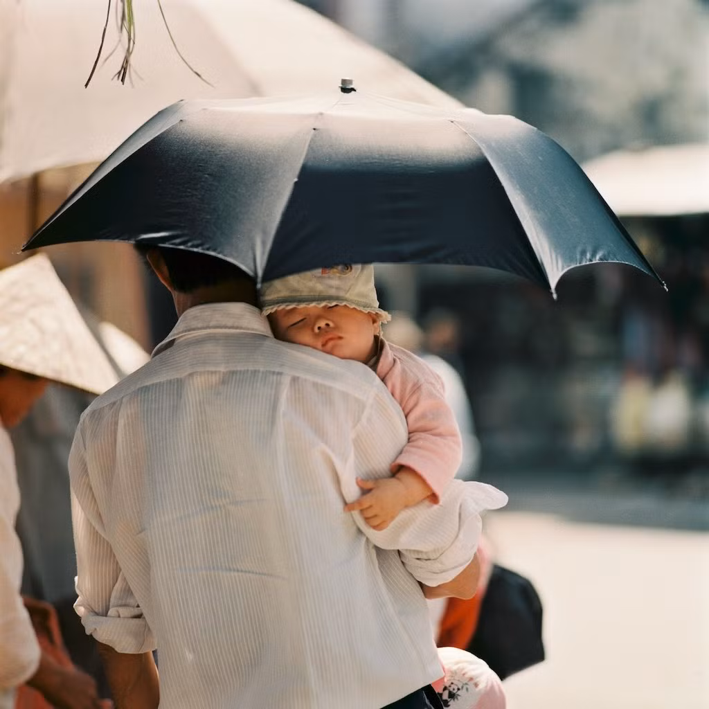 Cậu bé ngủ trong tay bố trên đường phố Trung Quốc thập niên 1970. Ảnh: Thomasbillhardt.de.