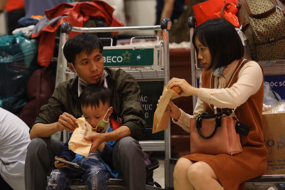 Nhiều gia đình tranh thủ ăn tạm bánh mình trong lúc chờ đợi.