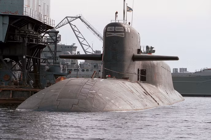 Tàu ngầm hạt nhân Novomoskovsk (K-407) thuộc lớp Delfin trong hạm đội Biển Bắc của Nga. Được hạ thủy từ năm 1990, tới năm 1992 tàu ngầm hạt nhân K-407 chính thức được biên chế vào Hạm đội Biển Bắc. Tàu có độ giãn nước tối đa khi lặn 18200 tấn, tốc độ tối đa 24 hải lý trên giờ, biên chế đủ 135 thủy thủ đoàn cùng sỹ quan. Tàu được trang bị 14 tên lửa RSM-54 trên 16 giếng phóng, 4 ống phóng ngư lôi 533 mm và có khả năng mang theo tối đa 12 ngư lôi. Nguồn ảnh: TASS.