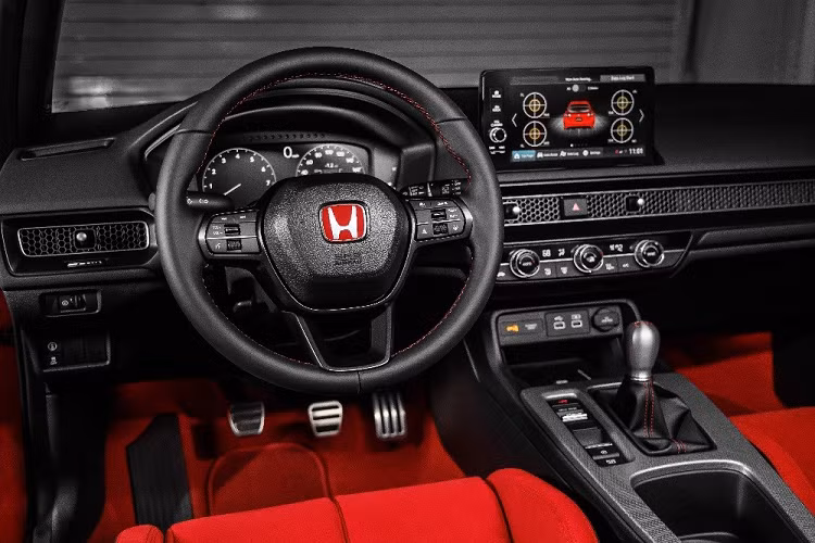 Honda Civic Type R 2023 sở hữu bảng đồng hồ kỹ thuật số 10,2 inch, màn hình thông tin giải trí 9 inch, bộ bàn đạp bằng kim loại, sạc điện thoại thông minh không dây, phanh tay điện tử và tự động giữ phanh tạm thời. Trên tấm lưới tổ ong của cửa gió điều hòa có thêm tấm biển nhỏ đánh dấu số thứ tự xuất xưởng của xe.
