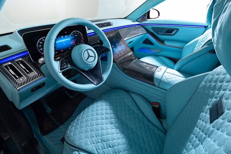 Khoang nội thất của bản độ Brabus 600 Masterpiece mang màu xanh ngọc cực kỳ nổi bật. Các chi tiết như ghế ngồi, bảng điều khiển trung tâm, vô lăng, thảm và tấm lót đầu đều được bọc da màu xanh, kết hợp đường khâu kim cương hình vỏ sò khá thú vị.