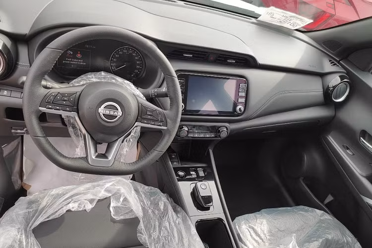 Bên trong Nissan Kicks e-Power 2023 là không gian nội thất 5 chỗ ngồi với ghế và mặt táp-lô bọc da, đi kèm chỉ khâu màu tương phản. Vô lăng của xe được thiết kế vát đáy thể thao, tích hợp các phím chức năng. Phía sau vô lăng là bảng đồng hồ kết hợp giữa analog và màn hình kỹ thuật số. Bên cạnh đó là màn hình cảm ứng trung tâm 8 inch, nằm bên dưới cửa gió điều hòa. Phía dưới màn hình trung tâm sẽ là 2 núm xoay và các nút chỉnh điều hòa.