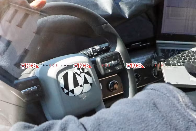 Bên trong cabin, Hyundai Kona 2023 sẽ có thiết kế khác hẳn với mẫu xe hiện hành. Theo hình ảnh trên mẫu xe thử nghiệm có thể thấy rằng Kona thế hệ mới sẽ có những đường nét “vay mượn” từ mẫu SUV điện Ioniq 5. Cụ thể là bảng điều khiển hiện đại hơn với bảng đồng hồ kỹ thuật số và màn hình thông tin giải trí liền khối, vô lăng đa chức năng bốn chấu mới, khu vực ốp cửa cũng có thêm các họa tiết khác màu tạo điểm nhấn.
