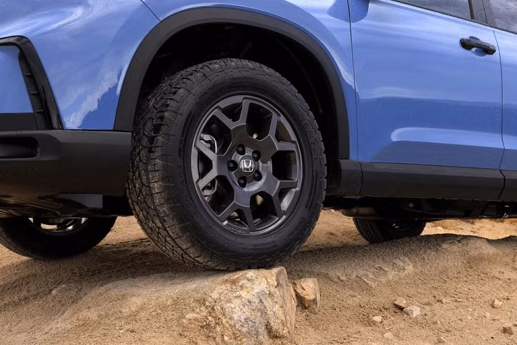 Tương tự nắp ca-pô, sườn xe của Honda Pilot 2023 cũng có những đường gân dập nổi ấn tượng. Bên dưới là nẹp hốc bánh và nẹp sườn xe màu đen cùng các loại vành có đường kính 18 inch hoặc 20 inch, tùy phiên bản. Ở phía sau, mẫu SUV này được trang bị đèn hậu LED mới, nối liền với nhau bằng nẹp màu đen ở giữa, tích hợp dòng chữ "Pilot" khá lớn. 