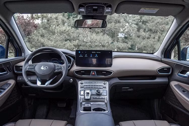 Bên trong Hyundai SantaFe 2023 phiên bản 6 chỗ là không gian nội thất bọc da phối 2 màu với 3 hàng ghế. Hàng ghế trước có tính năng sưởi ấm và làm mát. Ở giữa là 2 ghế thương gia, tách rời với nhau và đi kèm bệ tì tay riêng. 2 ghế này có thể chỉnh bằng tay và có tính năng sưởi. Trong khi đó, hàng ghế cuối cùng có thể gập chỉnh điện và được trang bị cửa gió điều hòa.