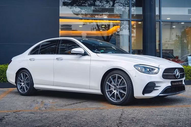 Cụ thể, theo giới tư vấn bán hàng, phiên bản tiêu chuẩn Mercedes-Benz E180 2022 mới được bổ sung 6 tính năng mới gồm bệ cửa phát sáng, cửa hít, rèm che nắng và cổng sạc USB Type-C cho hàng sau, cảnh báo điểm mù và cốp điện. Xe vẫn đi kèm mâm 5 chấu kép 18 inch, đèn pha LED dạng chóa hay màn hình kép 12,3 inch. Giá xe Mercedes-Benz E-Class 2022 tăng từ 2,050 tỷ lên 2,099 tỷ đồng.
