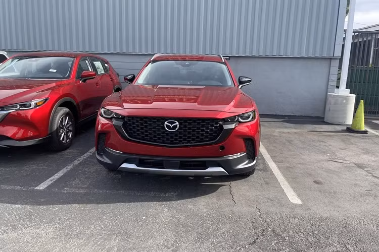 Là phiên bản off-road của CX-5 nên Mazda CX-50 2022 có thiết kế ngoại thất hầm hố và thể thao hơn. Vẫn được áp dụng ngôn ngữ thiết kế "Kodo" đặc trưng của thương hiệu Nhật Bản, mẫu xe SUV Mazda CX-50 2022 mang trên mình lưới tản nhiệt sơn màu đen. Ngay cả viền lưới tản nhiệt cũng được sơn màu đen bóng và nối liền với cụm đèn pha hai bên.