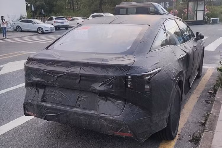 Phía sau, Toyota bZ5 đi kèm cụm đèn hậu LED có vẻ nối liền với nhau và ăn sâu vào chắn bùn ở hai bên. Thêm vào đó là cánh gió sau khá nhỏ, tích hợp vào cửa cốp. Chưa hết, những hình ảnh chụp trên đường thử còn hé lộ thiết kế nội thất của Toyota bZ5. Bên trong mẫu xe này có vô lăng 3 chấu và bảng đồng hồ kỹ thuật số khá hẹp, đặt ngang trên mặt táp-lô.