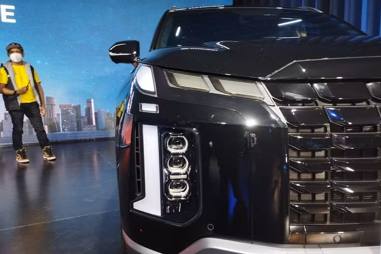 Tương tự xe ở thị trường Bắc Mỹ và Hàn Quốc, Hyundai Palisade 2023 cũng được thay đổi đáng kể trong thiết kế ngoại thất. Theo đó, xe được trang bị lưới tản nhiệt Cascading Grille rộng hơn với mắt lưới mạ crôm nổi bật hơn. Tương tự lưới tản nhiệt, hốc gió trung tâm bên dưới cũng đã được mở rộng và bao quanh bằng viền dày dặn. Nối liền với lưới tản nhiệt là dải đèn LED định vị ban ngày của xe.