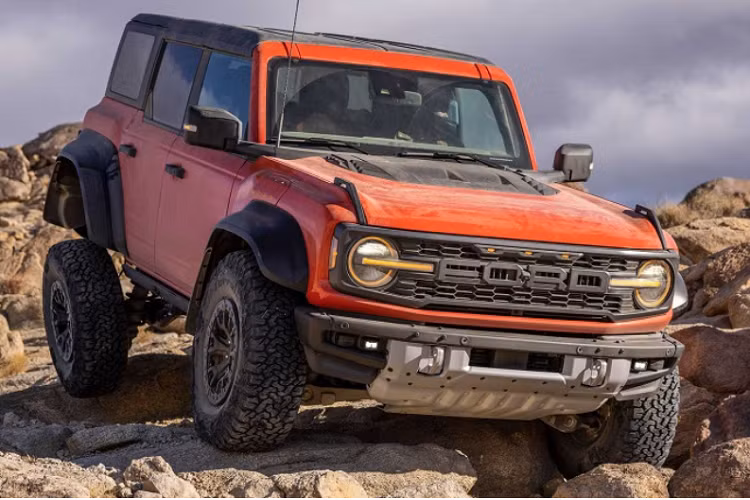 Các thay đổi trực quan trên Bronco Raptor bao gồm bộ mâm 17 inch đi kèm lốp địa hình BFGoodrich K02, vòm bánh mở rộng sơn đen, nắp capo và lưới tản nhiệt Raptor, cản trước Ford Performance tích hợp tời kéo, phối màu cam sáng nổi bật, cụm công cụ kỹ thuật số 12 inch với giao diện Raptor, ghế ngồi Ford Performance,...