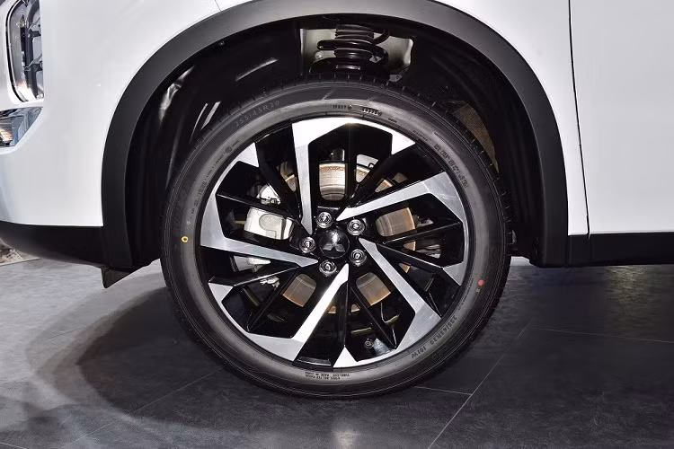 Tiếp đến là bộ vành hợp kim 20 inch với thiết kế đa chấu, lốp 255/45 R20, vòm bánh xe "cơ bắp", cửa sổ thẳng đứng cũng như cột D dày dặn. Đường chân kính mạ crôm, kéo dài lên cột D giúp tăng vẻ cao cấp cho mẫu SUV hạng C này. Đằng sau xe, Mitsubishi Outlander 2022 đi kèm cụm đèn hậu nằm ngang với thiết kế thanh mảnh, cửa cốp thẳng đứng, 2 đầu ống xả giả hình chữ nhật và ốp gầm màu bạc giống ở đầu xe.