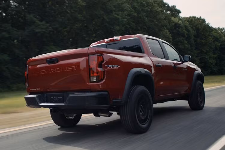 Lưới tản nhiệt đi kèm nẹp nằm ngang dày dặn, tích hợp logo của thương hiệu Chevrolet. Ở hai góc đầu xe còn có thêm hốc đèn sương mù trước. Riêng bản tiêu chuẩn sẽ đi kèm cản trước không sơn màu và không được trang bị đèn sương mù trước. Nhìn từ bên sườn, Chevrolet Colorado 2023 tiếp tục gợi liên tưởng đến đàn anh Silverado nhờ nắp ca-pô dập gân thể thao và chắn bùn trước/sau. Nối giữa 2 chắn bùn là một đường dập gân nổi bật.
