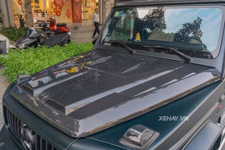 Di chuyển ra phía đuôi, Mercedes-AMG G63 được lắp líp gió bằng sợi carbon, cánh gió cỡ lớn dạng 2 mảnh và nắp ốp bánh xe dự phòng cấu tạo hoàn toàn bằng sợi carbon. Thiết kế của nắp ốp này được dập nổi các đường nét lấy cảm hứng từ chính logo của hãng độ này.
