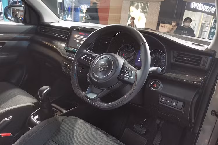 Bên trong Suzuki Ertiga Hybrid 2022 tại Indonesia là không gian nội thất không có gì khác biệt so với trước. Xe vẫn được trang bị ghế bọc nỉ, mặt táp-lô ốp gỗ, vô lăng vát đáy thể thao, tích hợp phím chức năng và màn hình đa thông tin nằm bên trong bảng đồng hồ. Thêm vào đó là màn hình thông tin giải trí dạng cảm ứng 8 inch và màn hình kỹ thuật số của hệ thống điều hòa.