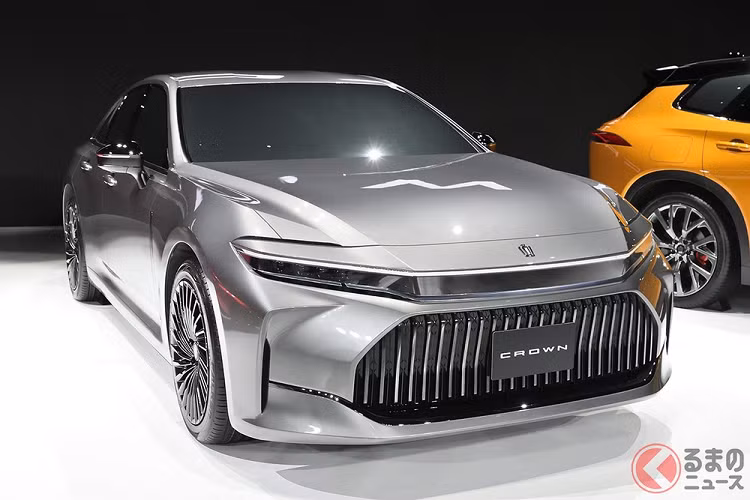 Lưới tản nhiệt của Toyota Crown Sedan 2024 nằm thấp bên dưới với thiết kế hình bát giác cỡ lớn. Bên trong lưới tản nhiệt là những nan nằm dọc, gợi liên tưởng đến xe sang Maserati. Ngoài ra, viền bên dưới của lưới tản nhiệt còn kéo dài sang hai bên, đến khe gió nằm dọc ở hai góc đầu xe. Vòng sang bên sườn, chúng ta sẽ bắt gặp bộ vành hợp kim đa chấu với thiết kế như vòng xoáy hút mắt. Bên cạnh đó là đường dập gân kéo dài từ chắn bùn trước đến cột D và từ cửa sau đến đuôi xe.