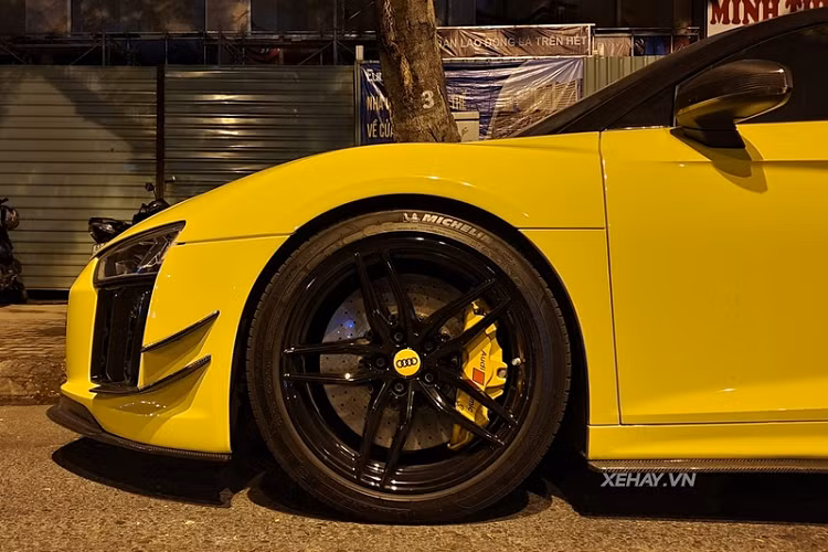 Chiếc Audi R8 V10 Plus màu vàng này được trang bị bộ mâm năm chấu kép sơn đen khá hầm hố, ẩn bên trong là đĩa phanh carbon ceramic kết hợp với cùm phanh sơn vàng tương tự lớp decal ngoại thất. Tương tự như cản trước đuôi xe cũng được làm mới với thiết kế cứng cáp.