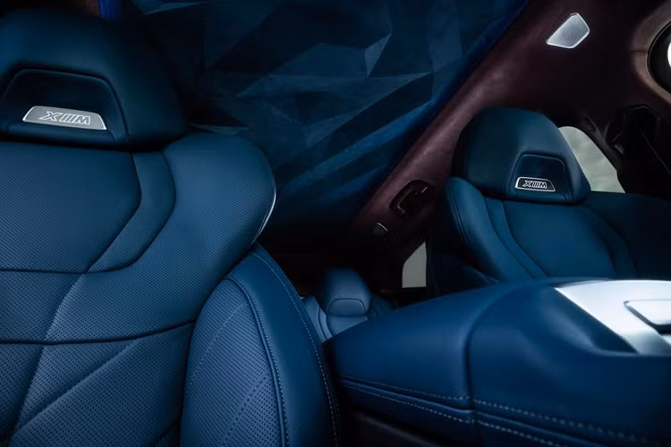 Trong đó, mặt táp-lô và cụm điều khiển trung tâm của BMW XM 2023 không khác quá nhiều so với X7 phiên bản nâng cấp. Ngoài ra, xe còn có bảng đồng hồ kỹ thuật số nối liền với màn hình cảm ứng trung tâm. Tuy nhiên, khác với BMW X7, XM vẫn dùng cần số thông thường. Mặt táp-lô và tappi cửa có thể bọc bằng chất liệu da Merino màu nâu cà phê cổ điển tùy chọn. Trong khi đó, ghế cũng như nửa dưới của mặt táp-lô và tappi cửa được bọc da màu xanh Deep Lagoon tương phản. Riêng trần xe được bọc da với họa tiết đẹp mắt.