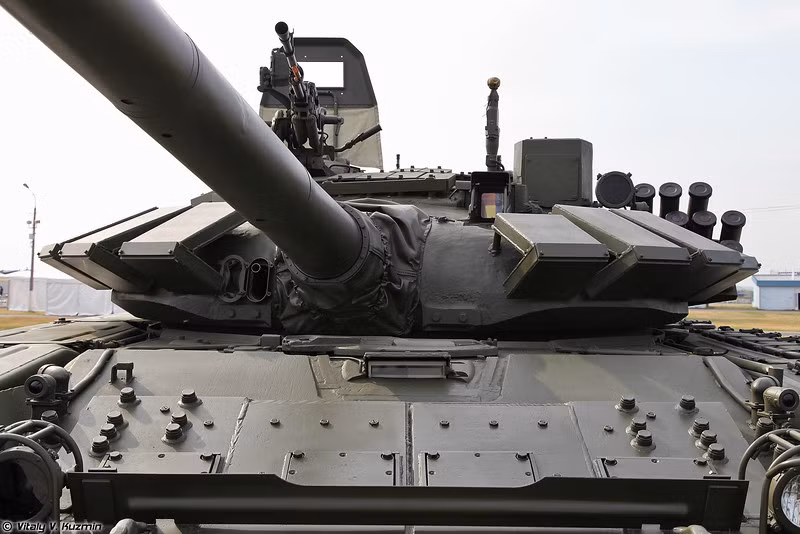 Hiệu quả của giáp Kontakt-5 đã được xe tăng T-90A chứng minh là tuyệt vời tại chính chiến trường Syria. Chưa ghi nhận trường hợp nào T-90A bị phá hủy hoàn toàn, hay là đạn xuyên giáp chọc thủng được giáp bảo vệ của T-90 dùng Kontakt-5. Trong ảnh, các tấm giáp Kontakt-5 được thiết kế kiểu vỏ sò bọc quanh tháp pháo của xe tăng T-72B3. Nguồn ảnh: Vitaly-Kuzmin