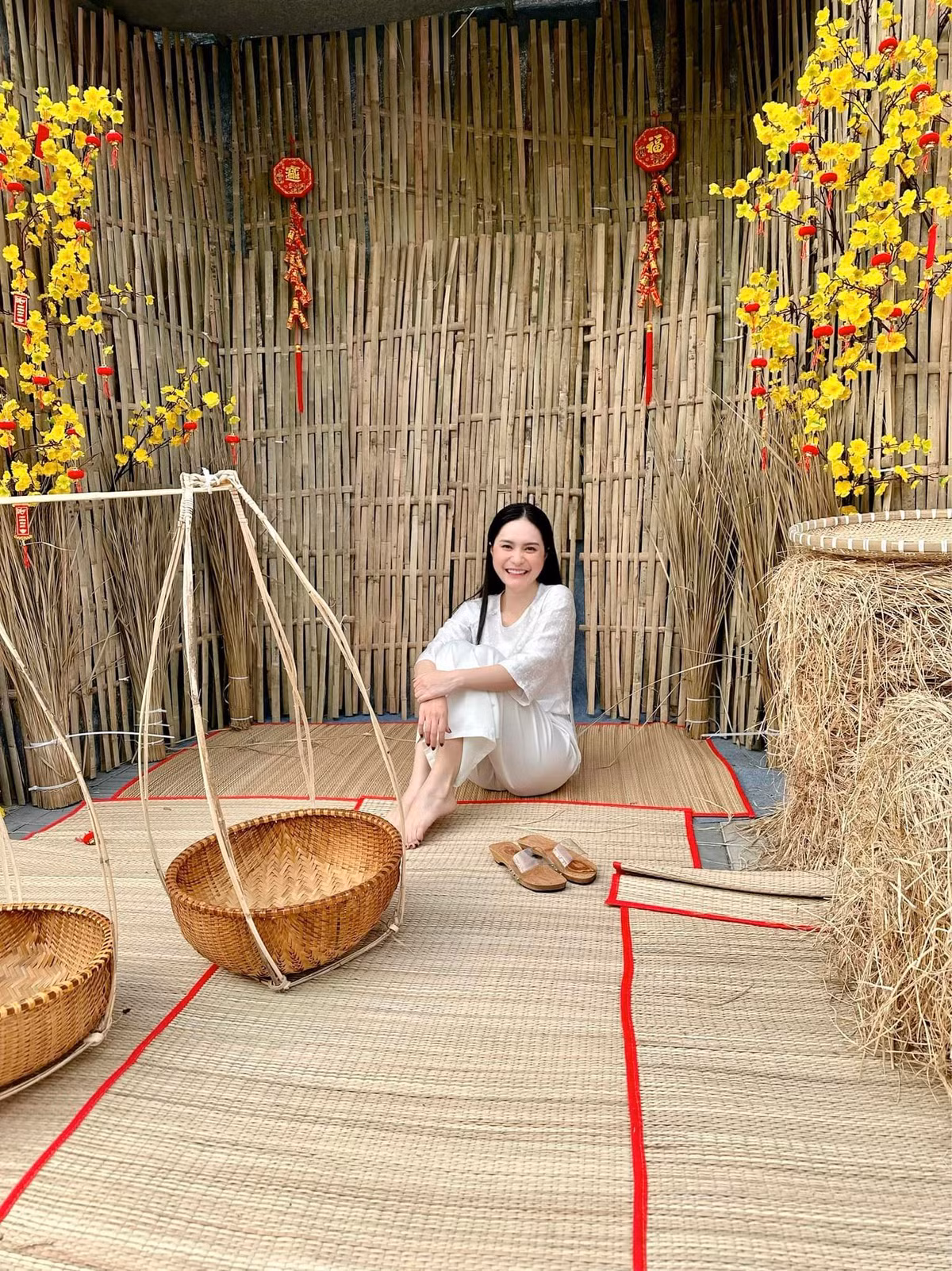 Đoàn Di Băng đã đầu tư cầu kỳ, tỉ mỉ hẳn một khu chợ Tết với nhiều chi tiết như rơm, gỗ mộc, tre, hoa cúc, chiếu cói,... để không gian chợ thêm phần giống ở đời thật.