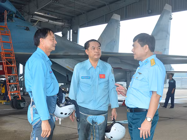 Đại tá Bùi Đức Thành - Chính ủy Sư đoàn 370 (ngoài cùng bên phải) trao đổi, động viên các phi công Trung đoàn 935 sau chuyến bay.