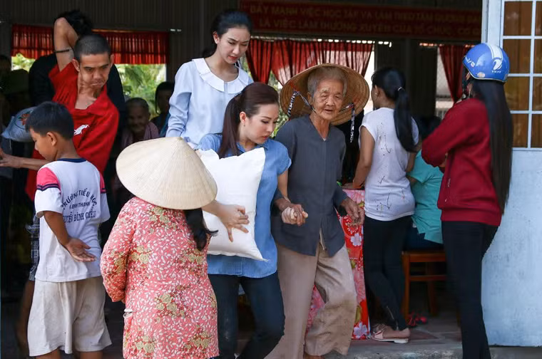 Đặc biệt, các người đẹp ngoài việc thăm hỏi, động viên và chúc tết bà con còn sẵn sàng bưng bê gạo, quà tết ra tận xe cho những cụ già sức khỏe yếu.