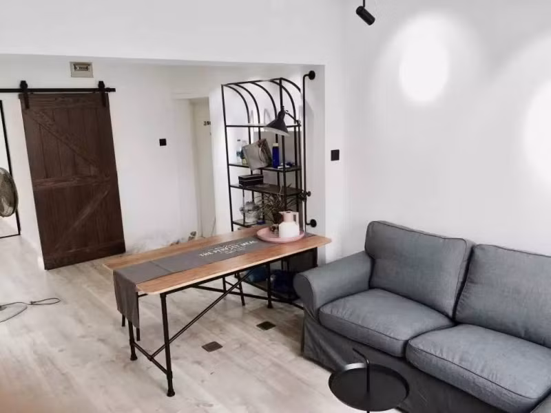 Phòng khách được ngăn cách với lối ra bằng một chiếc bàn đơn giản trông rất thuận mắt.