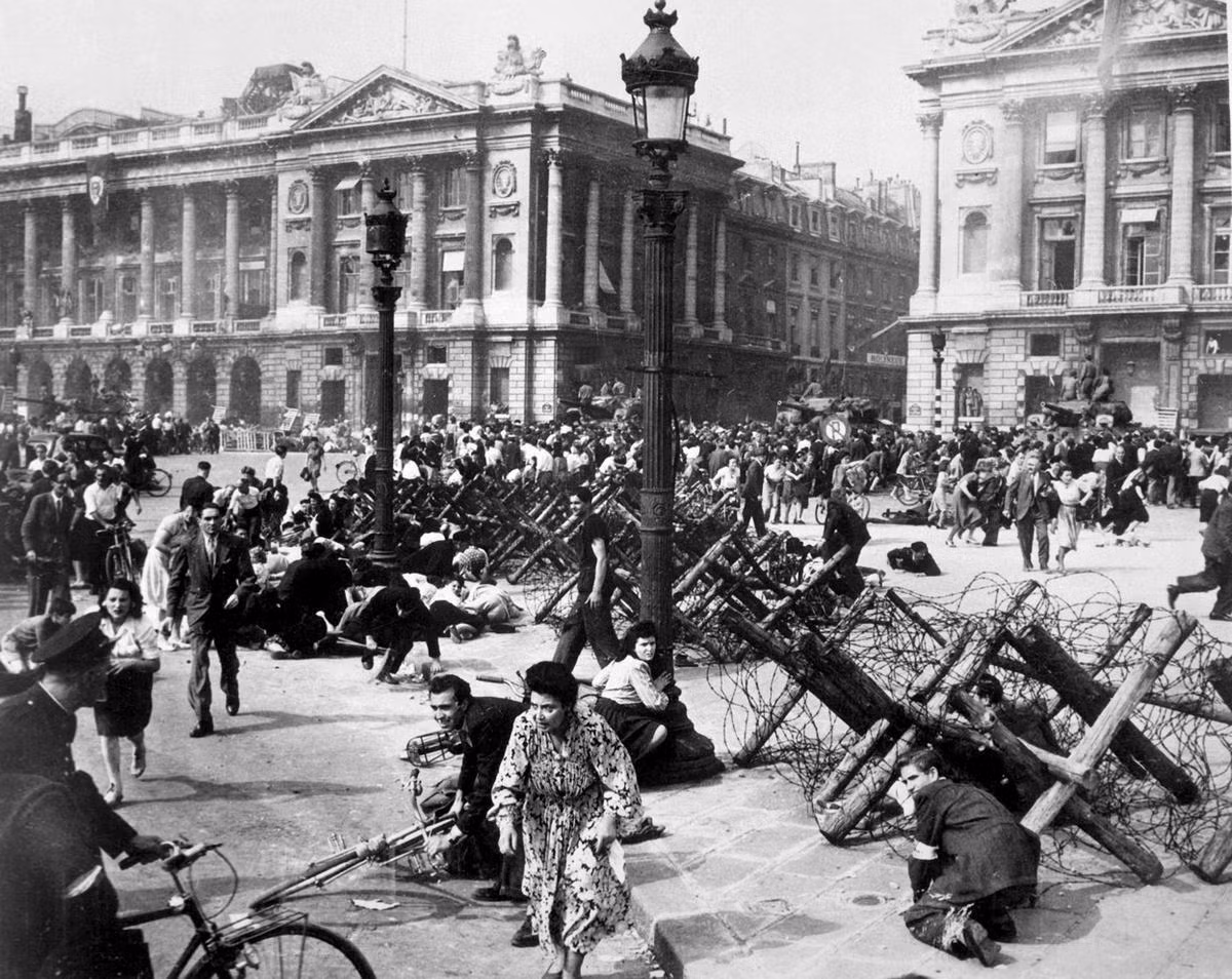 Quân Đồng Minh tiến vào Paris, vào khoảnh khắc bức ảnh này được chụp những người dân Paris và lính Đồng Minh phải nằm rạp xuống đất sau khi nghe thấy tiếng súng từ một tay bắn tỉa Đức. Sau khi chiếm được Paris phải mất cả tháng trời phía Đồng Minh cùng sự giúp sức của lực lượng du kích Pháp mới kiểm soát được hoàn toàn thành phố. Nguồn ảnh: Theatlantic.