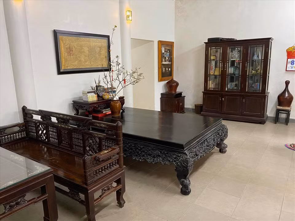 Mọi ngóc ngách trong nhà đều được đặt bàn ghế, phản gỗ cổ kính. Ảnh: Dân trí