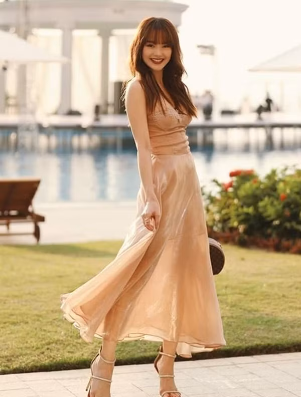 Trong đám cưới của cặp đôi vàng Vbiz Đông Nhi và Ông Cao Thắng, Minh Hằng diện một bộ đầm hai dây với gam màu nude nền nã. Thiết kế vừa quyến rũ lại vừa ngọt ngào bay bổng được mix khéo léo cùng đôi sandals quai mảnh đính đá lấp lánh hack chân dài đỉnh cao. Bên cạnh đó, chiếc túi xách dáng hộp của Louis Vuitton càng khiến bộ trang phục thêm điểm nhấn thú vị.