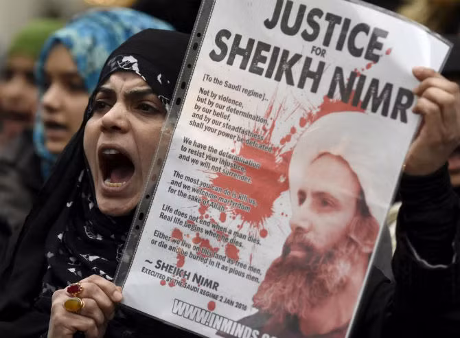 Người biểu tình mang theo ảnh của giáo sĩ Sheikh Nimr al-Nimr tập trung bên ngoài Đại sứ quán Ả-rập Xê-út ở London, Anh, ngày 3/1/2016.