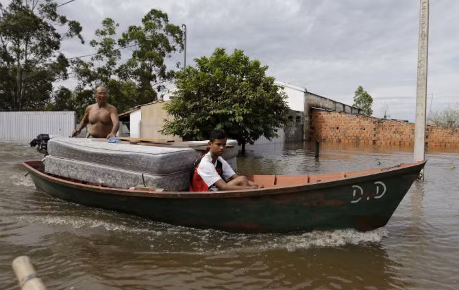Người dân Paraguay dùng thuyền để vận chuyển đồ đạc ra khỏi những ngôi nhà bị ngập gần sông Paraguay ở Asuncion ngày 27/12/2015. Hơn 100 nghìn người ở khu vực biên giới của Paraguay, Uruguay, Brazil và Argentina đã phải sơ tán vì lũ lụt nghiêm trọng trong đợt mưa lớn vào mùa hè do hiện tượng El Nino gây ra.