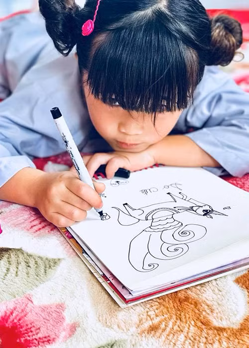 Con gái của danh hài Thúy Nga say mê vẽ tranh khi cùng mẹ đi chùa.