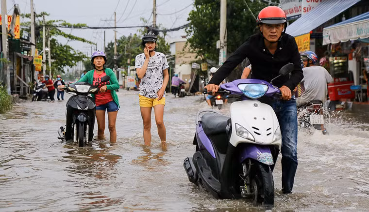 Nước dâng cao gần nửa bánh xe máy khiến nhiều phương tiện bị chết máy khi đang cố lưu thông qua dòng nước ngập trên.