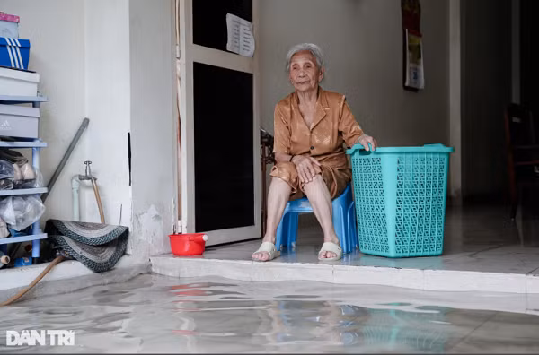Căn phòng khách của gia đình bà Nguyễn Thị Vương (94 tuổi) cũng sắp bị nước tràn vào."Tôi ở đây cả mấy chục năm rồi, khu vực này cứ mưa là sẽ ngập. Có hôm mưa lớn, nước tràn vào nhà, nhiều đồ đạc trong nhà tôi bị hỏng do ngâm nước", bà Vương chia sẻ.