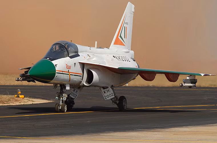 LCA Tejas là tiêm kích đa năng hạng nhẹ "khó đẻ" của công nghiệp quốc phòng Ấn Độ. Được phát triển từ những năm 1980 nhằm thay thế MiG-21, tới tận năm 2001 mới có chuyến bay đầu tiên và công tác thử nghiệm đã kéo dài ngót nghét 16 năm mà vẫn chưa thực sự trực chiến trong Không quân Ấn Độ, số lượng chế tạo vẫn ở mức các loạt thử nghiệm. Do đó, người Ấn dù không muốn vẫn phải duy trì số lượng lớn các máy bay MiG-21 đã cũ. Nguồn ảnh: Wikipedia