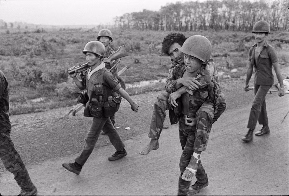 Một lính Sài Gòn cõng đồng đội bị thương ra trực thăng quân y ở An Lộc. Ảnh: Magnumphotos.com